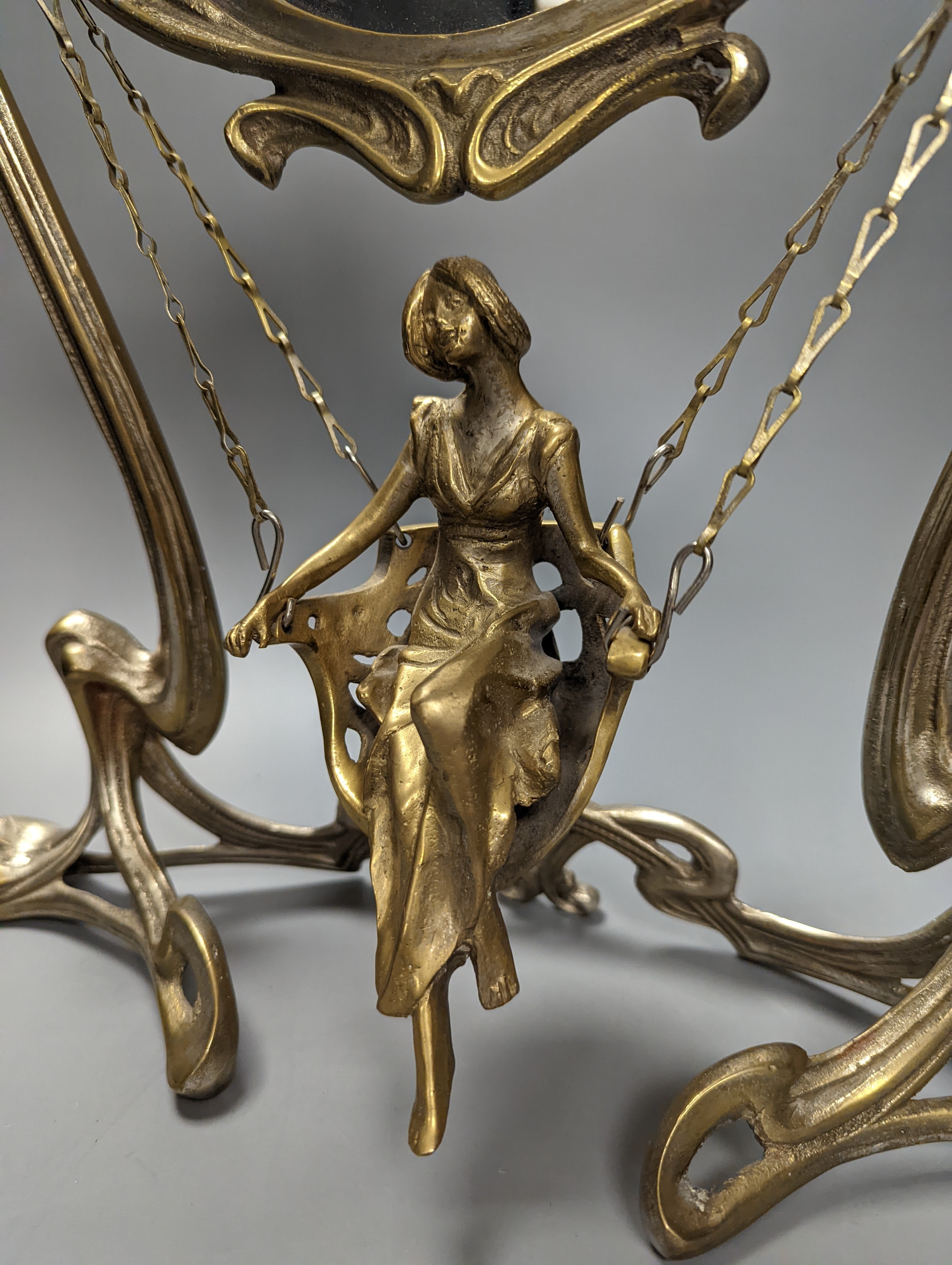 An Art Nouveau style mirror with model of girl sitting on a swing, height 45cm